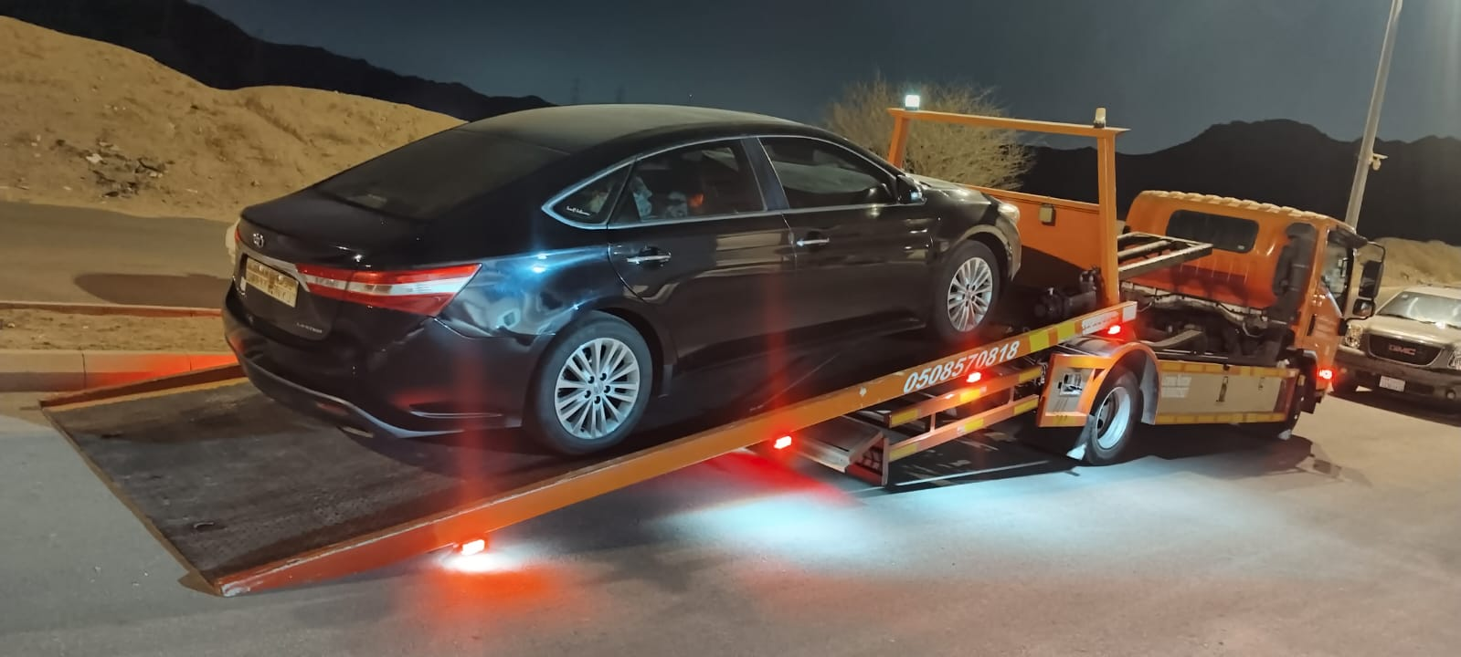 سطحة هيدروليك حمراء تنقل سيارة BMW فاخرة في الدمام